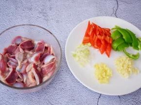 把清洗干净的鸡胗切成薄片，再加入盐、淀粉、食用油抓匀腌制半小时，青红椒去籽切小块，姜蒜葱切末