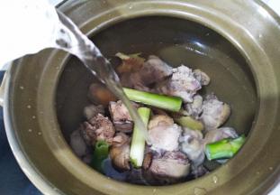 鸡肉大葱生姜放砂锅里，注入清水。