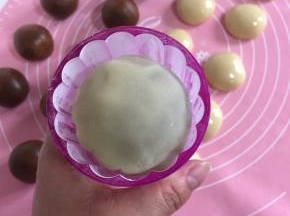 月饼模具中撒少许干粉，滚动模具使粉附着均匀，然后轻轻磕掉多余的粉！这样就很容易脱模了！把滚好粉的月饼胚放进模具中！轻轻按压一下！（这个时候可以把烤箱预热了！200度预热10分钟！）