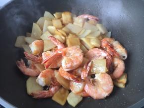 放入炸过的大虾，将大虾和土豆翻炒均匀，中小火烧5分钟左右。