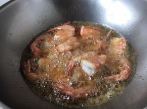 锅热后放油，油量宽些，当油温7、8成热时放入大虾，把大虾炸至变色，捞出备用。撇出一部分油，留做它用，留少许的油即可。