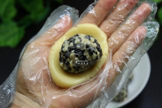 拿一小团月饼皮在手心按压，然后放入柠檬五仁馅馅，包裹起来；