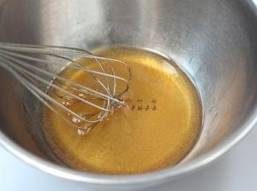 用手抽同方向搅拌两分钟，至糖浆布满细密的气泡，然后将枧水加入搅拌均匀的糖浆中，搅拌均匀