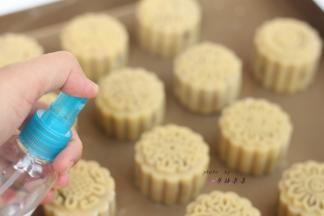 烘烤前用小喷壶在月饼上轻轻喷洒一点水雾，以避免月饼饼皮太过干燥而导致烘烤时开裂