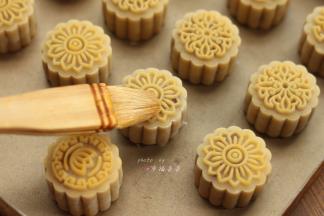 烤制8分钟后，取出烤盘，在每个月饼的花纹上刷一层薄薄的蛋黄液