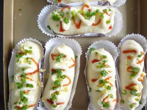 发酵完成后表面刷上清水放上芝士，挤上沙拉酱和番茄酱放上葱叶