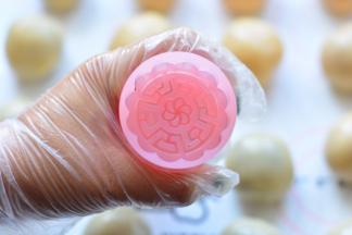 月饼模具里面放上自己喜欢的花片，在月饼模具里面沾少许的面粉，防
粘