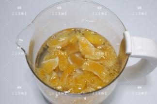 将剥好的橙子放入锅具，冰糖也一起放入，加入适量水