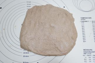 发酵好的面团倒扣出来，按压排气