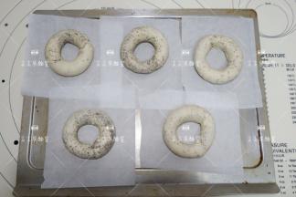 剪5个小块的油纸，依次将做好的贝果放上去，去35度的环境下发酵至胖一圈