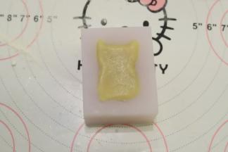 小猪的硅胶月饼膜里面均匀的抹上少许的色拉油，放入月饼胚，用力压紧