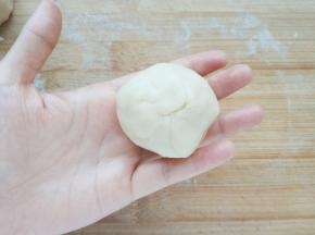 用虎口将饼皮边缘慢慢向内收拢，收紧收口。