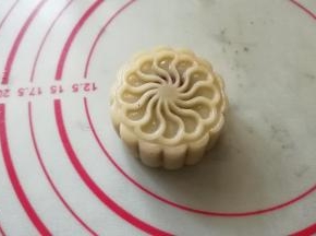 用模具将面团压成月饼形状。