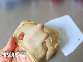 厨师机继续搅拌，慢速3分钟、中速4分钟，取出面团在台面上摔打几下，至面团能拉出薄膜即可。