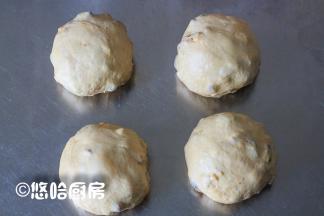 取出发酵到位的面团，分割成等量的4份，大致揉圆，盖保鲜膜醒发20分钟。