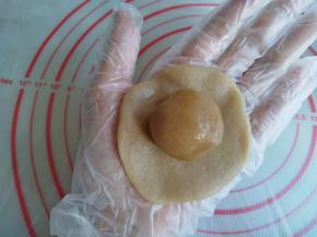 冰皮放在手掌上压扁，放上馅料