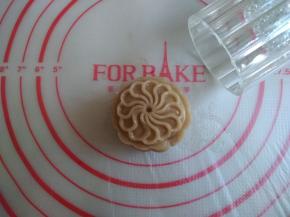 50克月饼模在熟糕粉里压一下，多余的粉抖去。将月饼圆坯放入模具里，在案板上向下压（力气不用太大，因为上面需要抹可可酱和撒可可粉，不需要图案清晰），提起月饼模