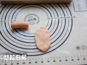醒发15分钟后，取一个面团压扁上下擀开成牛舌状，自上往下卷起。
