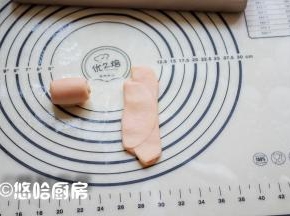 取一个醒发后的面团，收口朝上擀开，自上向下卷起。