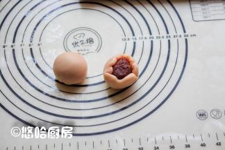 取一个面团将2头向内按压，擀开包入豆沙馅，用虎口向上推的方式收好口，捏紧收口。