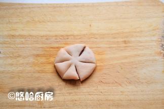 将包好豆沙馅的面团压扁，从外向内切开5个刀口，中间保留一点不要切断。