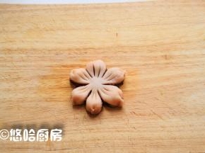 在面团的外围用手捏一下成花瓣的形状，用刀在中间割出花蕊的样子。