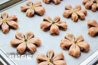 依次做好全部面团，面团之间留出间隔，摆放在烤盘上。在面团的中间用筷子点上一点蛋黄，撒一点黑芝麻或白芝麻。