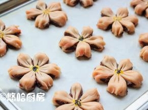 依次做好全部面团，面团之间留出间隔，摆放在烤盘上。在面团的中间用筷子点上一点蛋黄，撒一点黑芝麻或白芝麻。
