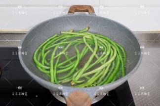 锅中注入水，加入一点盐，烧开后下入豆角焯至断生。