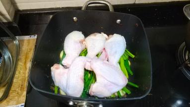 放入腌好的鸡翅、鸡腿，淋入三勺料酒