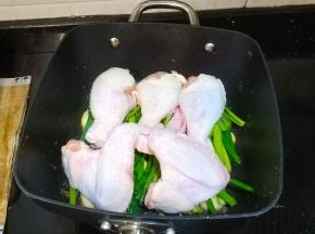 放入腌好的鸡翅、鸡腿，淋入三勺料酒