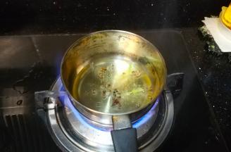 另起奶锅放入宽油和少许花椒，烧至滚热