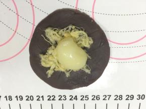 取一个内馅稍按扁，放入一点点肉松，再放入一块麻薯