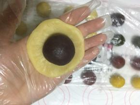 取一块桃山皮按扁，放入一块包好麻薯的内馅