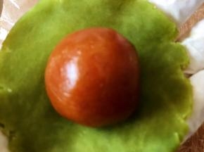 将抹茶桃山皮擀成薄片，把馅料包入