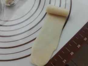 将擀过一次的卷，再次用擀面杖将其擀长，同样自上而下卷起来，如图所示。