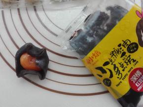 将豆沙馅直接手心按扁，将蛋黄包入，如图所示。