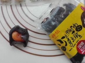 将豆沙馅直接手心按扁，将蛋黄包入，如图所示。