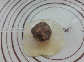 将上面醒发好的面剂，擀成圆形薄片，放入馅料。