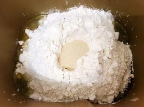 再加入高低筋面粉，对角分别放上盐和白糖，中间的粉堆埋入干酵母