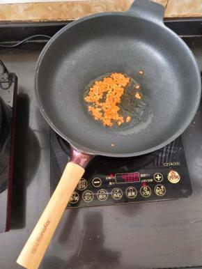 热锅凉油下胡萝卜丁，煸炒片刻。