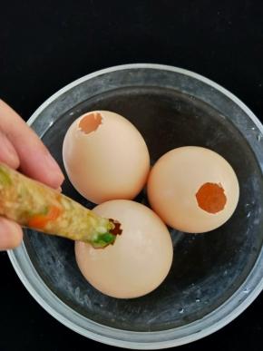 然后裱花袋剪个角，把馅料挤入鸡蛋里。