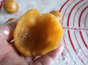 4.	取一份凤梨馅用大指按一下，呈现如图形状，