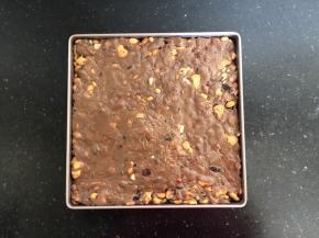 9、倒入学厨不粘烤盘中，待稍凉后按压平整后放入冰箱冷冻一个小时后取出，撒上一层薄薄的奶粉，用锋利的刀切成大小均匀的小块就可以了。