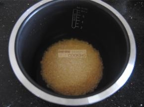 往大米里倒入一罐的茶水，盖上锅盖，启动煮饭键，大约十多分钟即可煮好。