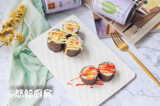 用利刃切开紫菜包饭，摆放在盘中，表面挤上少许的沙拉酱或者番茄沙司。