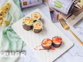 用利刃切开紫菜包饭，摆放在盘中，表面挤上少许的沙拉酱或者番茄沙司。