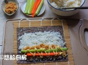 在卷帘上铺一张紫菜，铺上一层米饭，在卷帘的一侧铺一层肉松，放黄瓜条、胡萝卜条，挤上适量的沙拉酱。