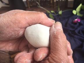 先将饺子皮对折，中间捏紧，然后用双手的拇指和食指将饺子皮的边向中间轻轻挤压。