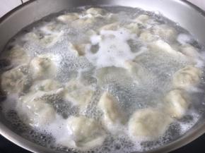 煮饺子时用汤勺朝一个放向搅动，期间水开后往里倒入一小碗的凉水，这样重复3～4次，饺子就熟了。
刚下锅后一定先用勺按照顺时针推水，这样饺子就不沉底，不粘锅啦。
饺子煮熟后用笊篱捞出来，控一下水份，然后装盘。